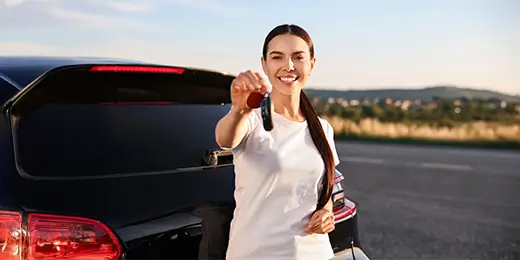 Mujer recibiendo el carro que compró sin cuota inicial con ChevyPlan