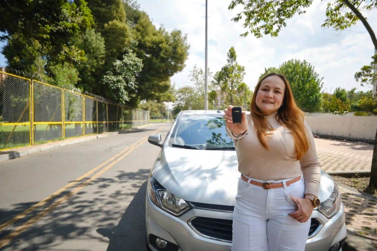 Mujer recibiendo su carro nuevo Chevrolet sin cuota inicial